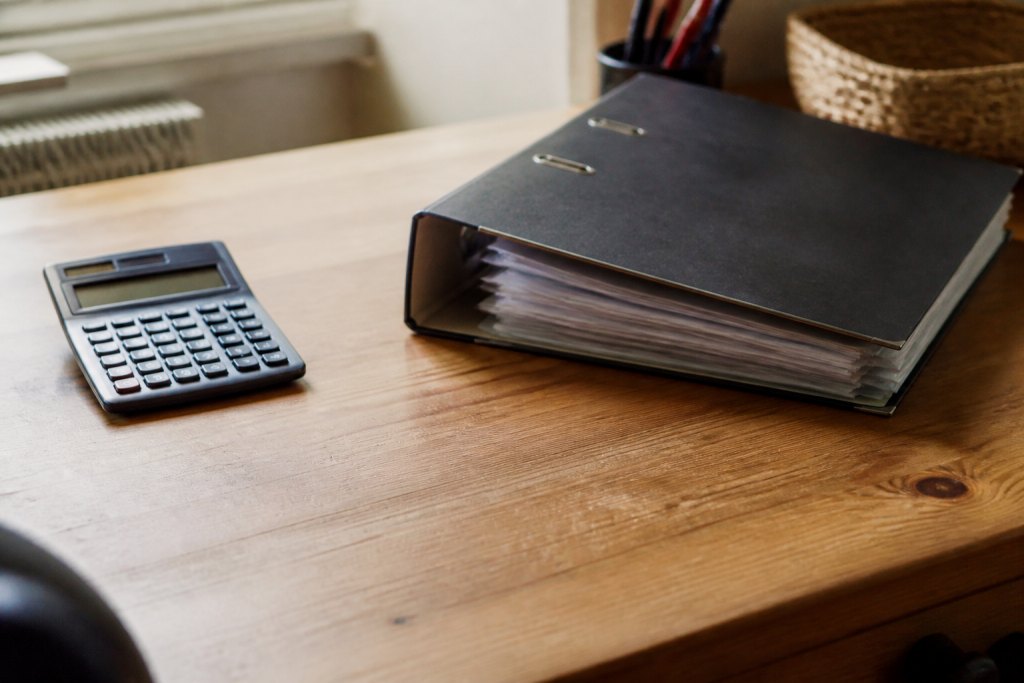 Bureau en bois avec calculatrice et classeur de factures