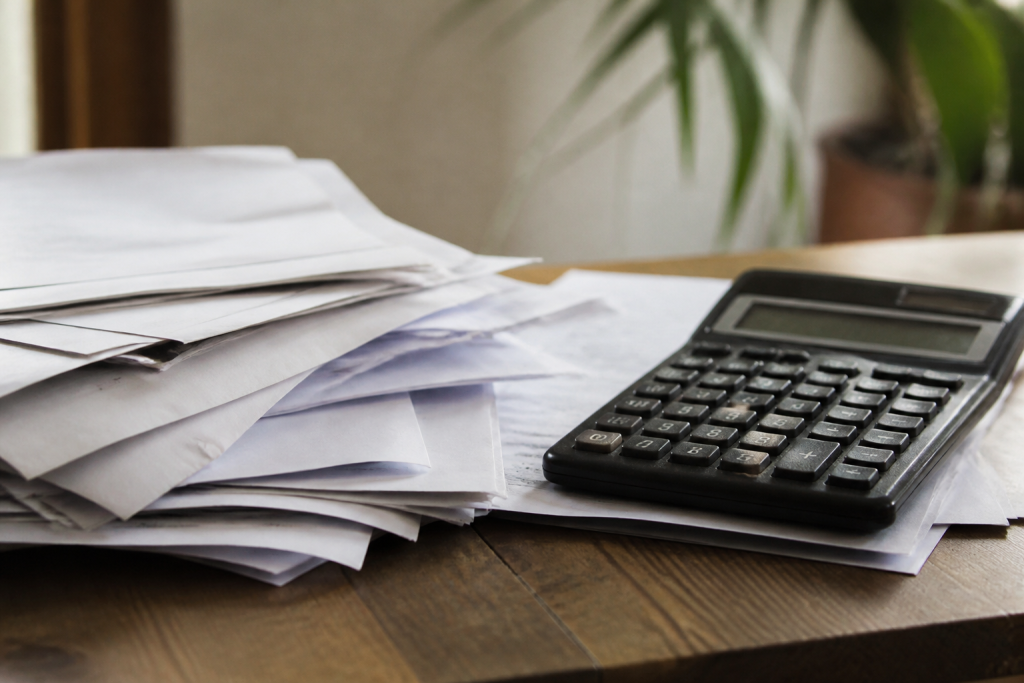 Calculatrice et factures posees sur un bureau en bois