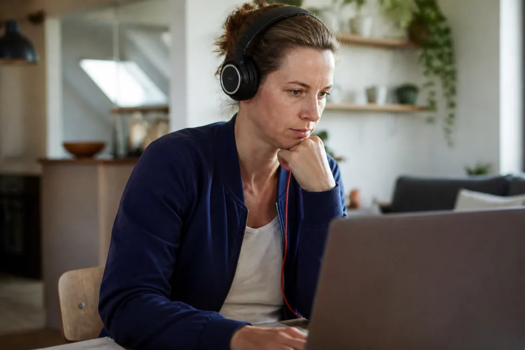 Femme assise devant un ordinateur portable avec casque