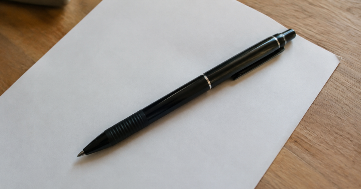 Stylo noir couche sur une feuille de papier blanc