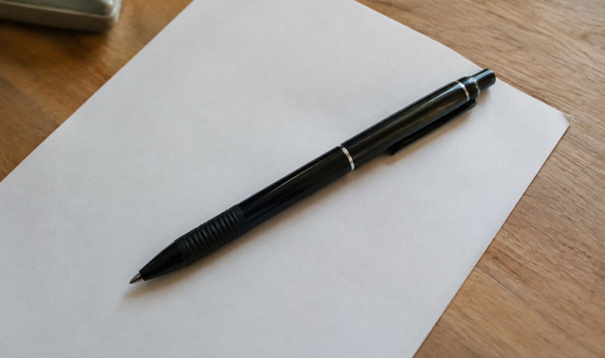 Stylo noir couche sur une feuille de papier blanc